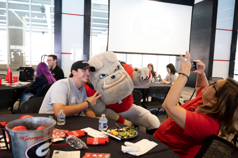 Hairy Dawg posing for a photo with a student at the Transfer Student Welcome